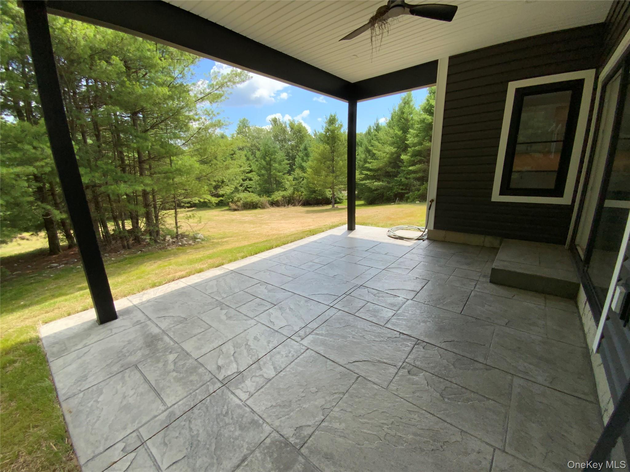 58 Dunn Town Road Wurtsboro, NY 12790 - Photo 17 of 36 a view of an empty room with a floor to ceiling window and a yard