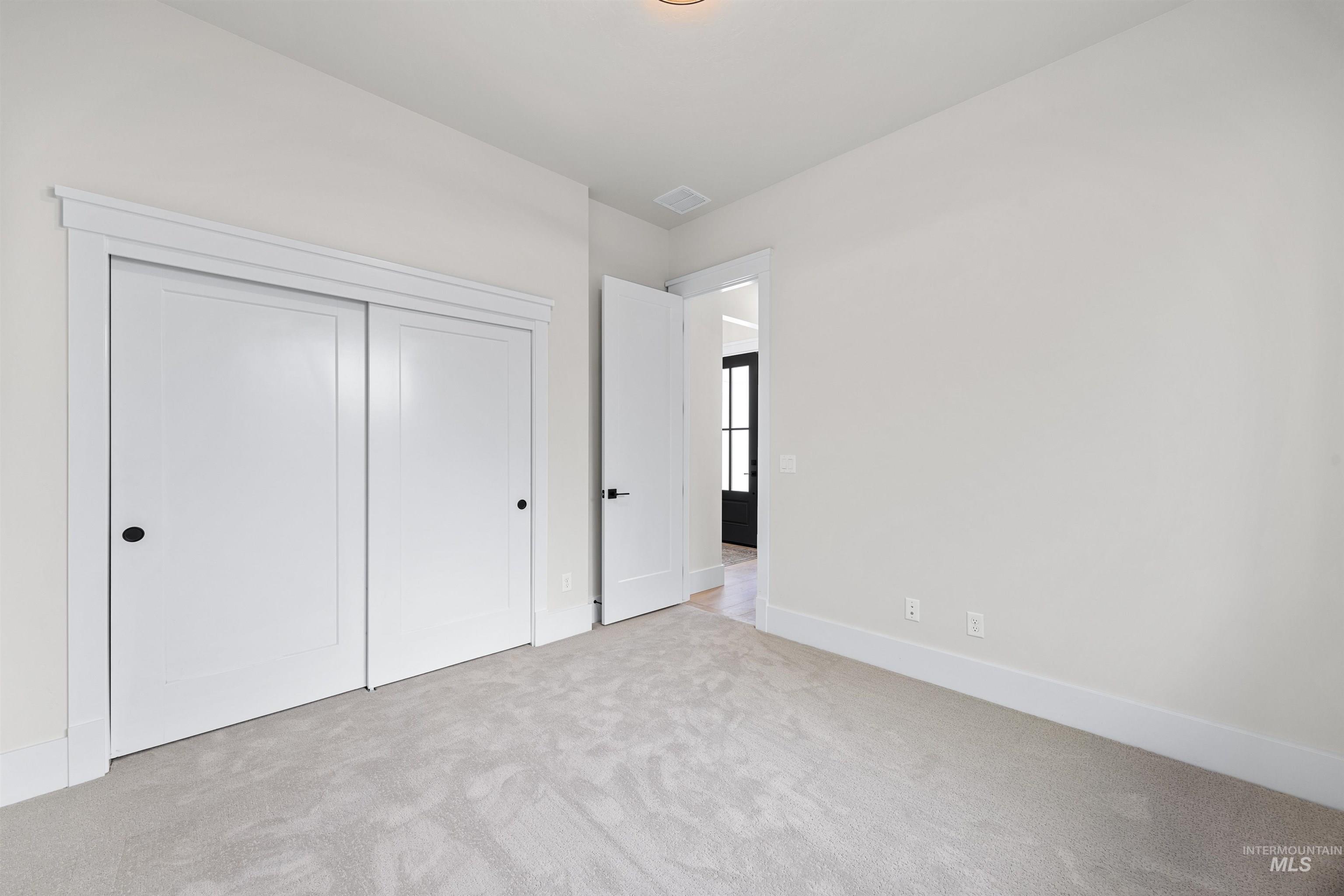 5940 South Pinpoint Way Meridian, ID 83642 - Photo 8 of 40 Neutral wall finishes, plush carpet flooring, recessed ceiling lighting, and crisp white trim