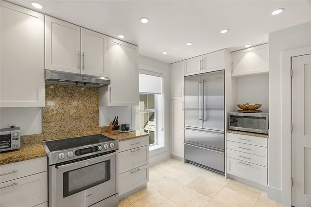 a kitchen with granite countertop cabinets and stainless steel appliances