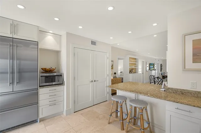 a kitchen with granite countertop a refrigerator and a sink