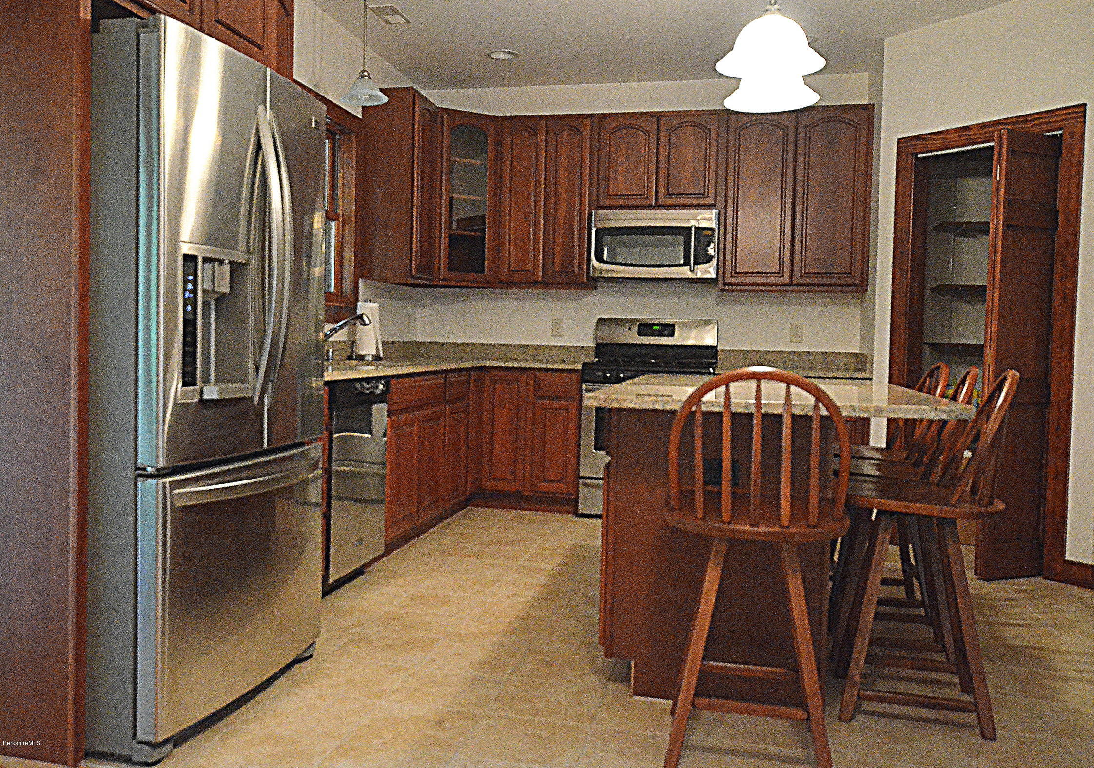 779 Stebbins Road Otis, MA 01253 - Photo 15 of 40 a kitchen with granite countertop stainless steel appliances a stove top oven a sink and a refrigerator
