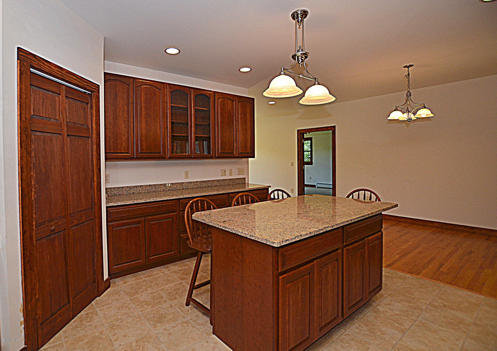 779 Stebbins Road Otis, MA 01253 - Photo 16 of 40 a kitchen with a wooden floor and a refrigerator