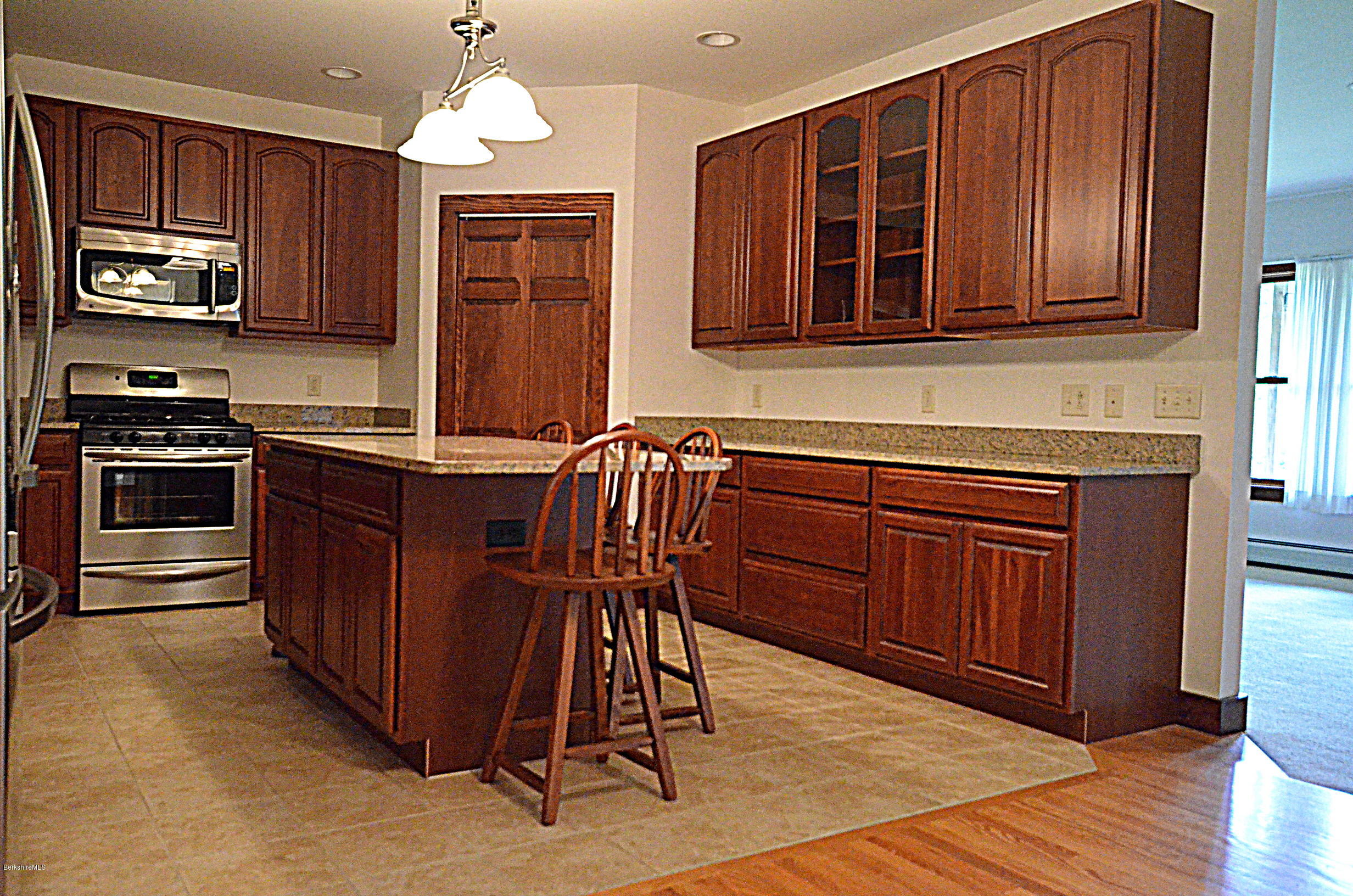 779 Stebbins Road Otis, MA 01253 - Photo 17 of 40 a kitchen with stainless steel appliances granite countertop wooden cabinets a stove top oven a sink and dishwasher