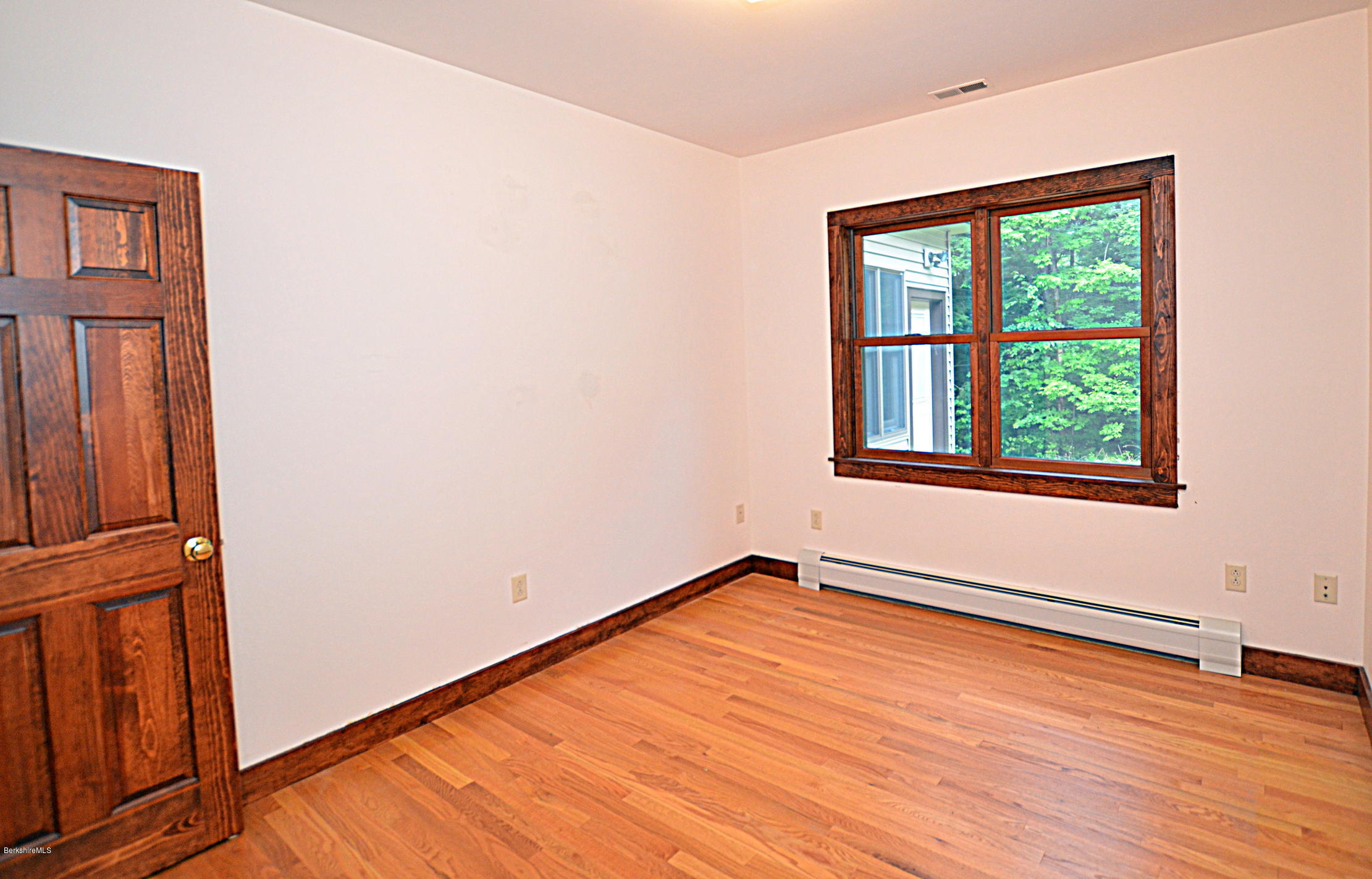 779 Stebbins Road Otis, MA 01253 - Photo 31 of 40 a view of an empty room with wooden floor and a window