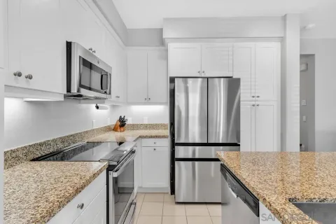 a kitchen with stainless steel appliances granite countertop a sink stove and refrigerator