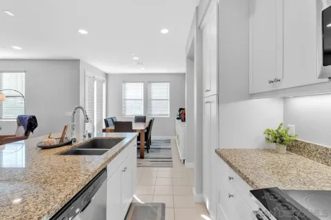 a kitchen with granite countertop a sink a counter top space and cabinets
