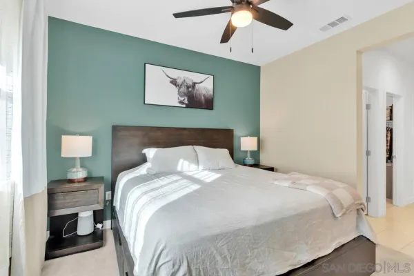 a bedroom with a bed and a painting on the wall