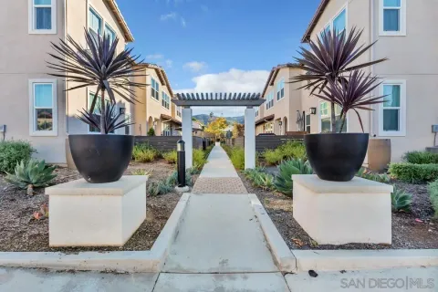 a view of a house with potted plants and large tree