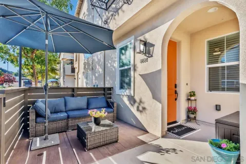 a balcony with furniture and umbrella