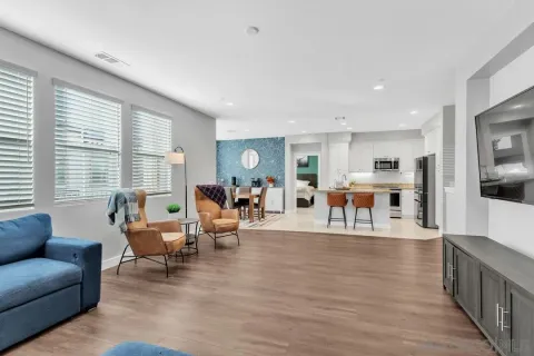 a living room with furniture wooden floor and a large window