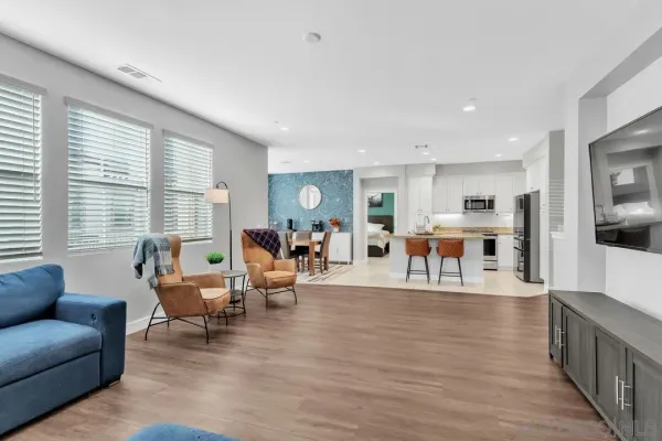 a living room with furniture wooden floor and a large window
