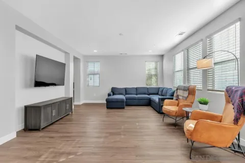 a living room with furniture wooden floor and a flat screen tv
