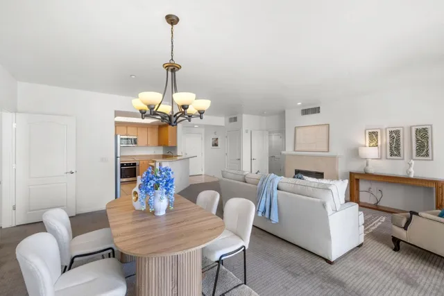 a view of a dining room with furniture a chandelier and wooden floor