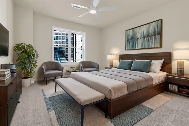 a bedroom with bed a couch and a window