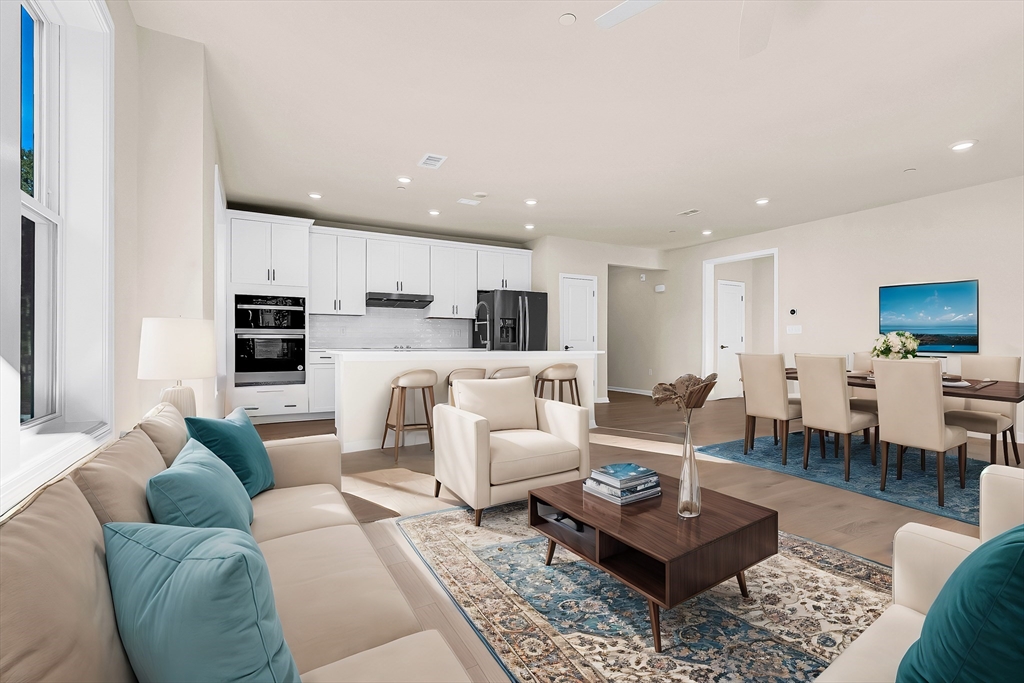 2 Winslow Lane, Unit 201 Grafton, MA 01536 - Photo 3 of 33 a living room with furniture a kitchen view and a wooden floor