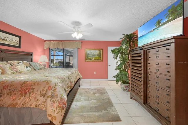 a spacious bedroom with a large bed and a chandelier