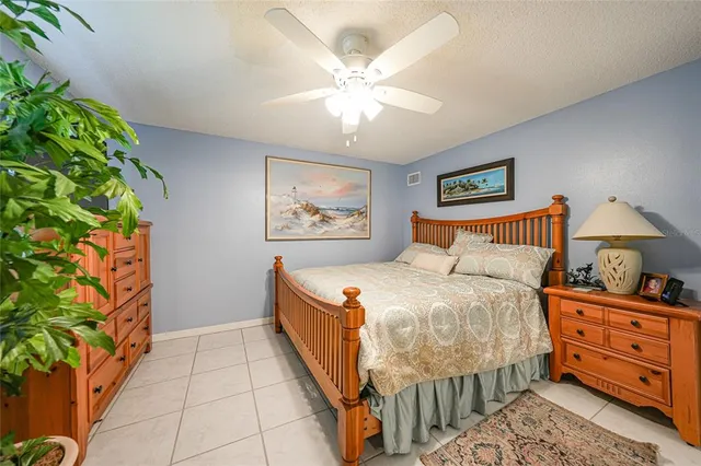 a bedroom with bed and paintings on the wall