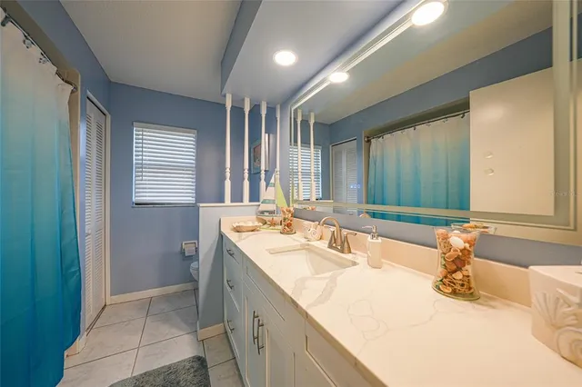 a bathroom with a granite countertop sink and a large mirror