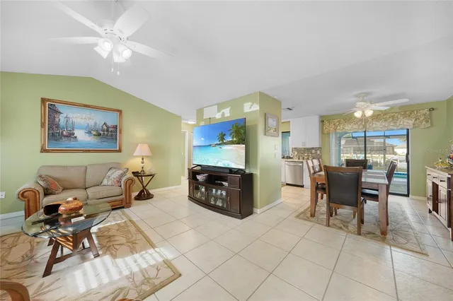 a living room with furniture a table and kitchen view