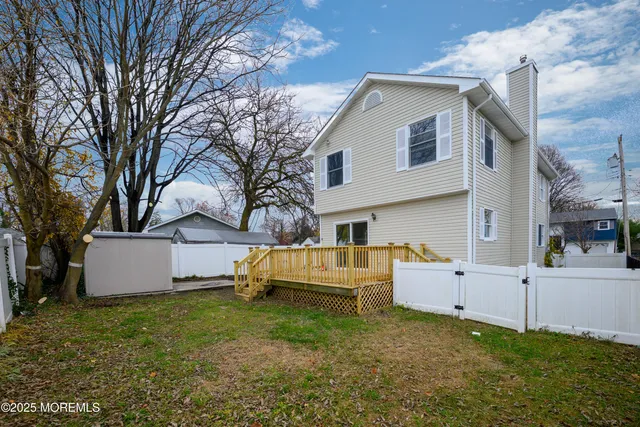a view of backyard of house with wooden fence