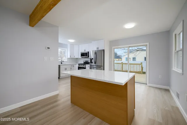 a view of kitchen with wooden floor and electronic appliances