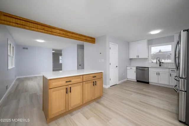 a large kitchen with a white cabinets and wooden floor