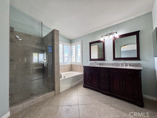 32948 Levi Court Temecula, CA 92592 - Photo 43 of 59 a bathroom with a bathtub a double vanity sink and mirror