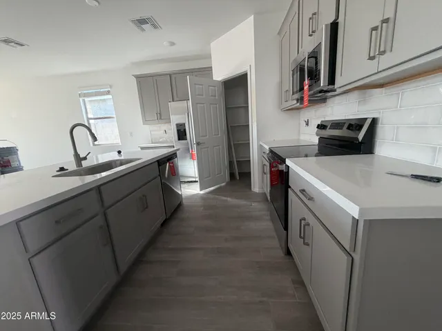a kitchen with stainless steel appliances a sink stove and cabinets