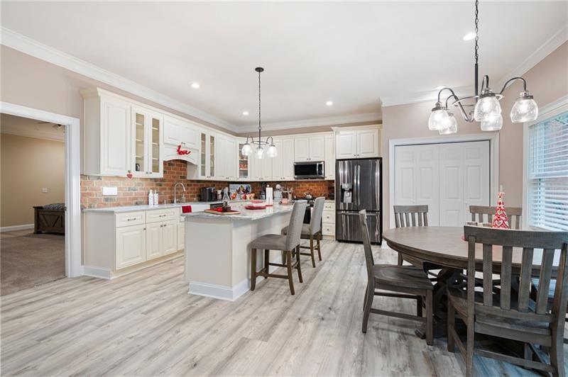 7131 Ridge Road Hiram, GA 30141 - Photo 41 of 63 a kitchen with a dining table chairs wooden floor cabinets appliances and a window