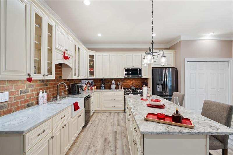 7131 Ridge Road Hiram, GA 30141 - Photo 42 of 63 a kitchen with stainless steel appliances kitchen island granite countertop a sink dishwasher and white cabinets with wooden floor