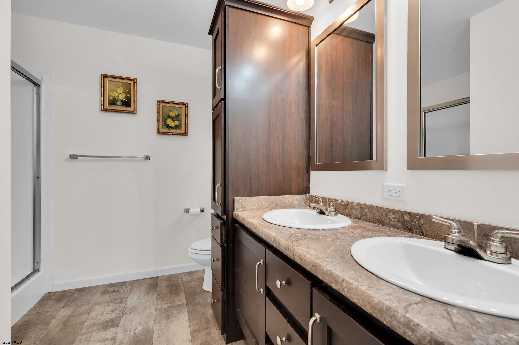 2058 South Shore Road, Unit 104 Marmora, NJ 08230 - Photo 12 of 20 a bathroom with a granite countertop sink and a mirror