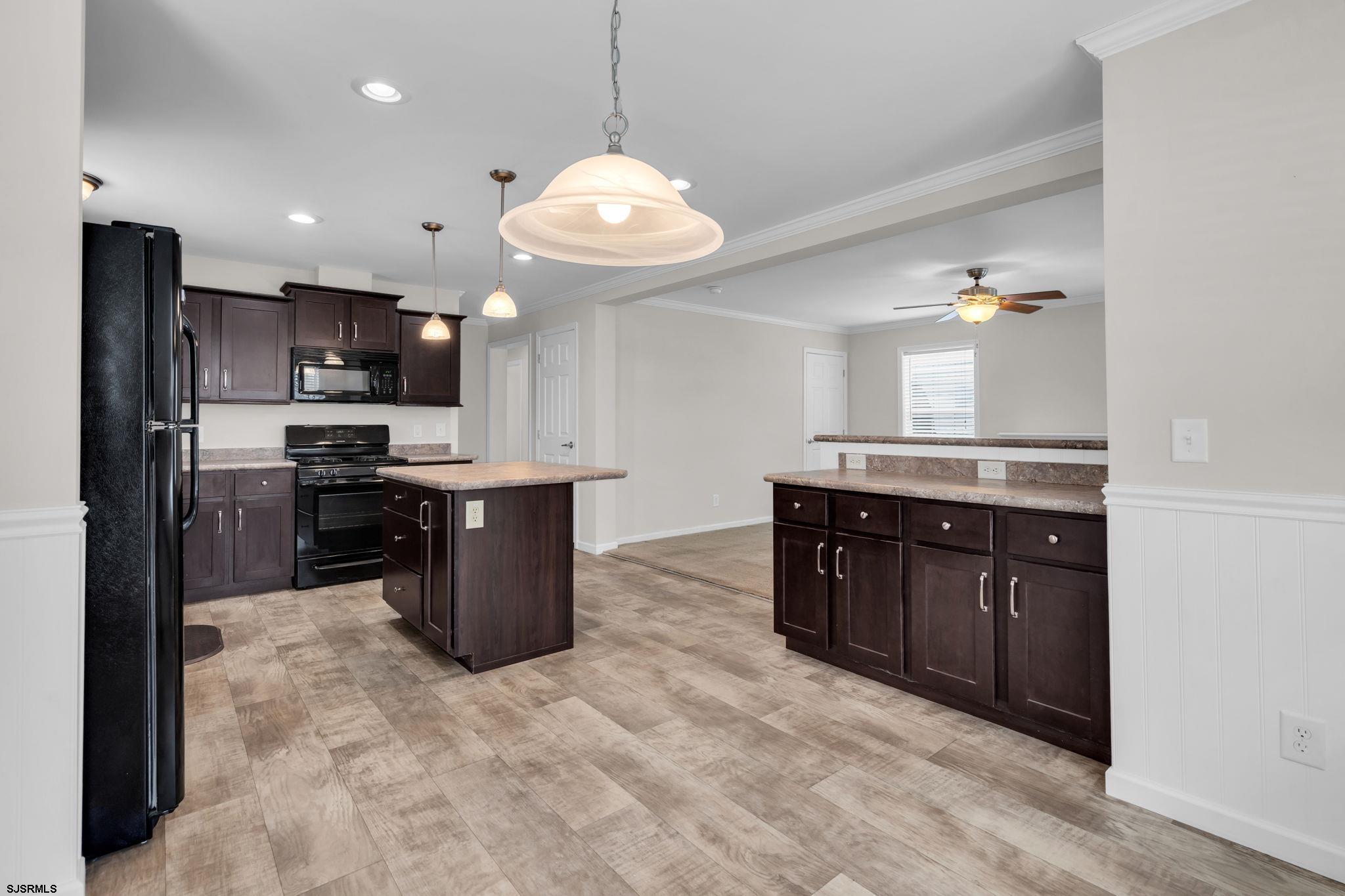 2058 South Shore Road, Unit 104 Marmora, NJ 08230 - Photo 8 of 20 a kitchen with stainless steel appliances granite countertop a refrigerator a stove a sink a microwave and island