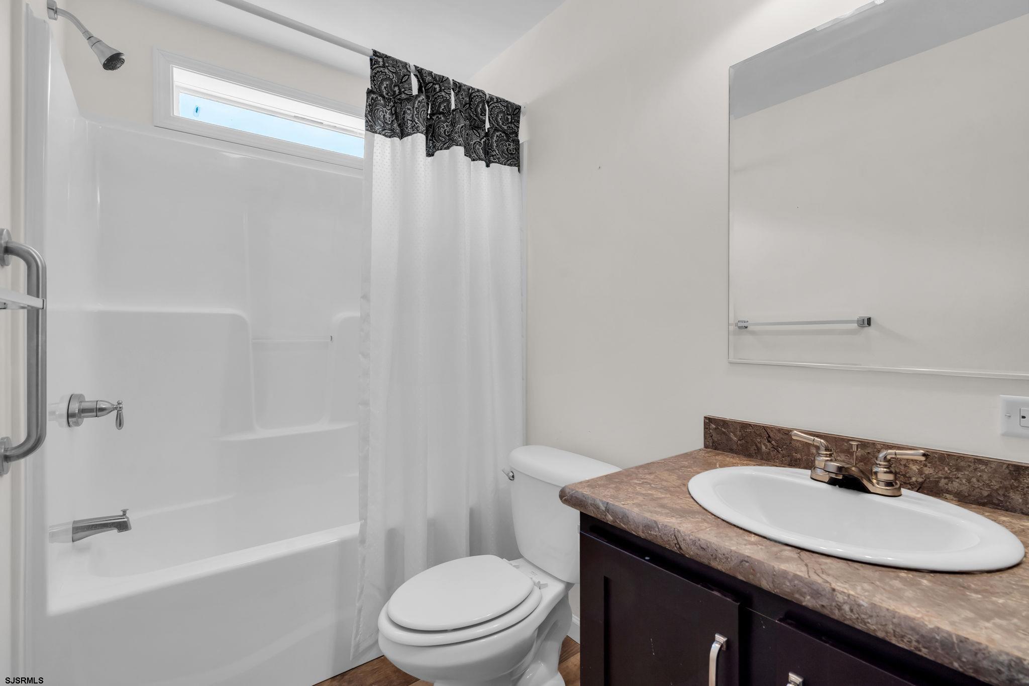 2058 South Shore Road, Unit 104 Marmora, NJ 08230 - Photo 9 of 20 a bathroom with a granite countertop sink toilet and shower