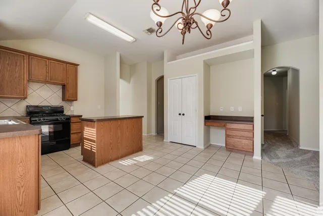 a kitchen with stainless steel appliances granite countertop a refrigerator a stove and a sink