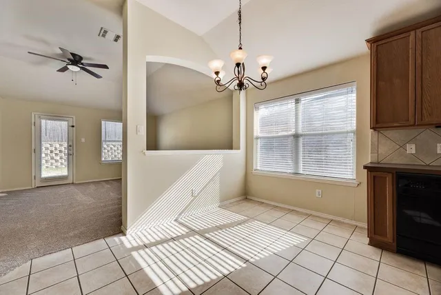 a view of an empty room with a fireplace and a window