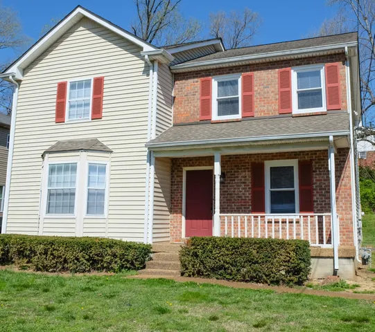 a view of a brick house with a small yard
