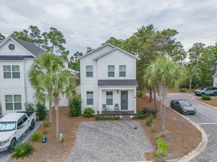 a view of a house with a yard and large tree
