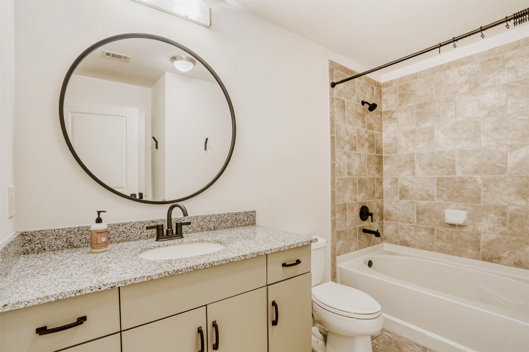 360 Nueces Street, Unit 2004 Austin, TX 78701 - Photo 33 of 34 a bathroom with a granite countertop sink a toilet and a mirror