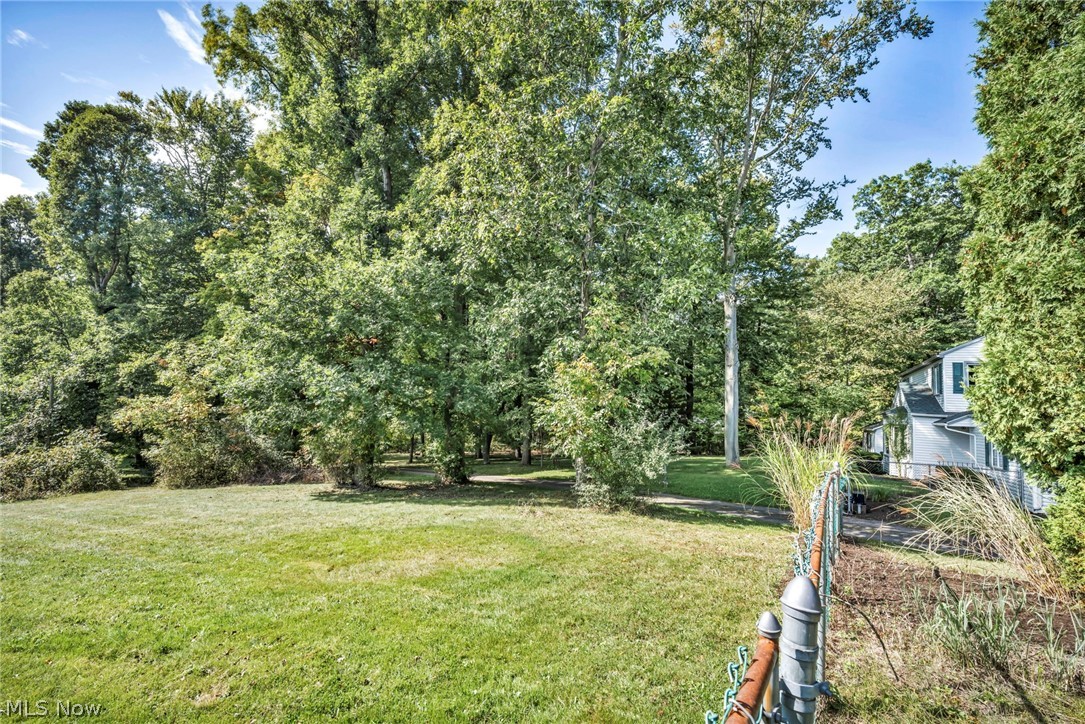3583 West Bath Road Akron, OH 44333 - Photo 41 of 42 Expansive green lawn surrounded by mature trees, featuring a partial chain-link fence