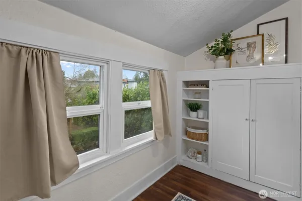 a view of hallway with window and wooden floor