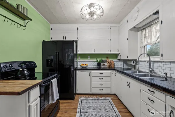 a kitchen with granite countertop a refrigerator and a sink