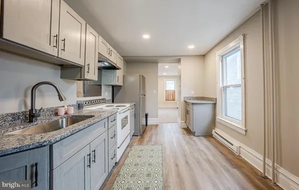 a kitchen with sink a refrigerator and cabinets