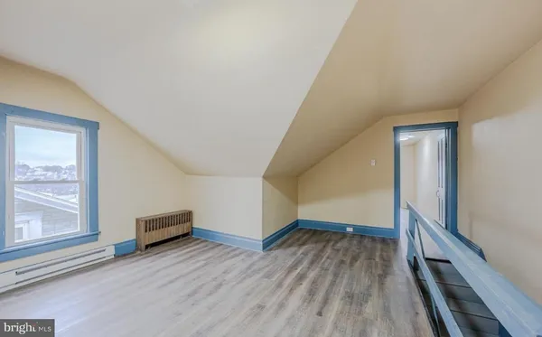 a view of empty room with wooden floor