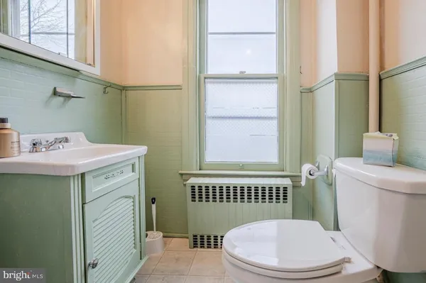 a bathroom with a sink a toilet and a mirror