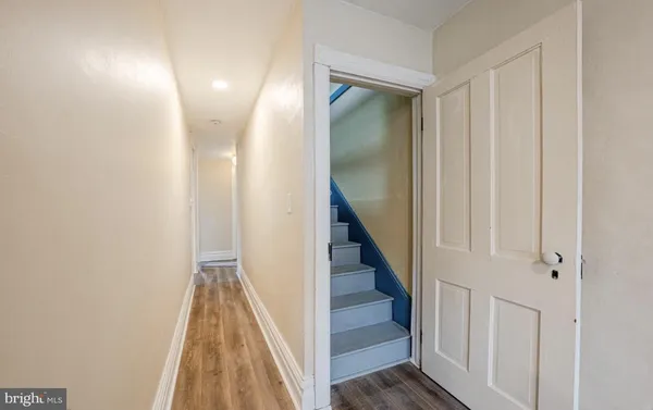 a view of a hallway with wooden floor and entryway