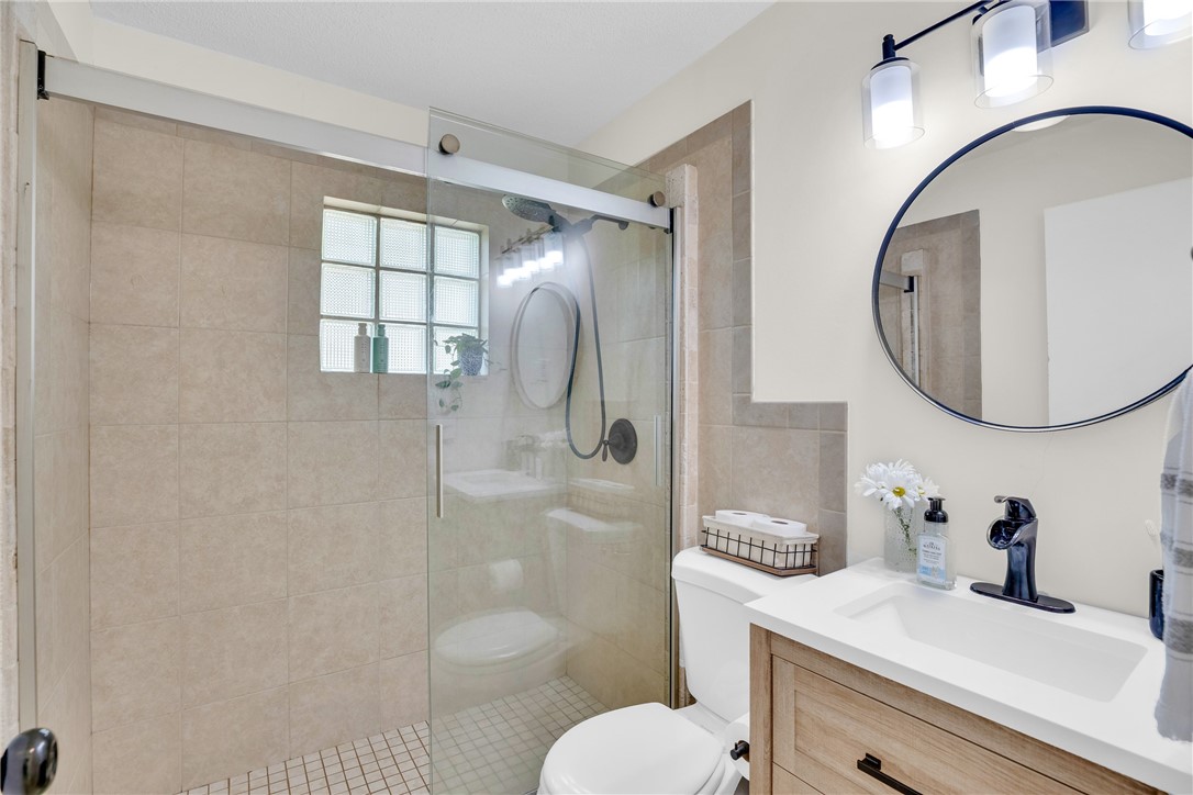 3655 2nd Place Vero Beach, FL 32968 - Photo 15 of 27 a bathroom with a sink toilet a mirror and shower