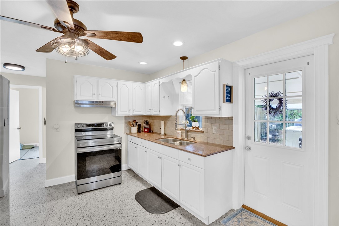 3655 2nd Place Vero Beach, FL 32968 - Photo 10 of 27 a kitchen with kitchen island a stove cabinets and wooden floor