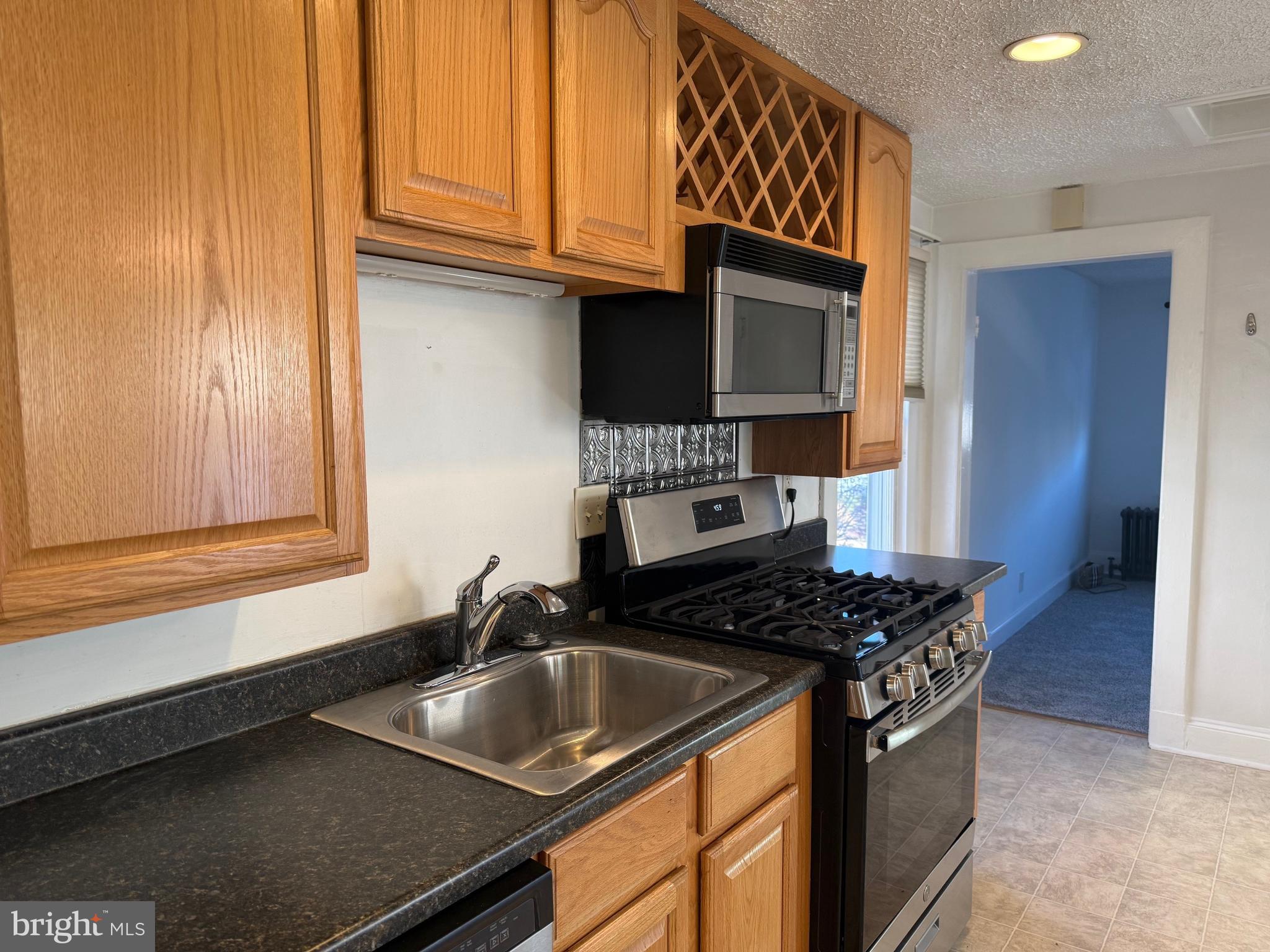 15 Brewer Avenue, Unit B Annapolis, MD 21401 - Photo 11 of 26 a kitchen with granite countertop a sink stove and cabinets