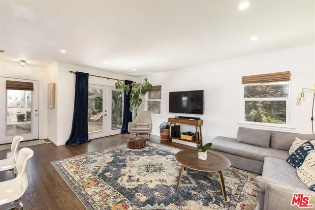 a living room with furniture a flat screen tv and a large window