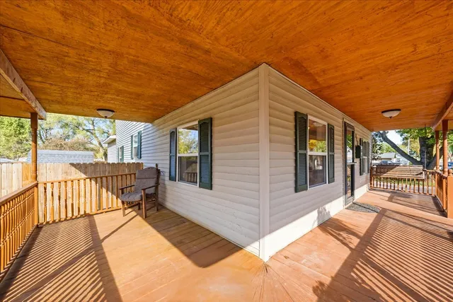 a balcony with wooden floor and outdoor seating